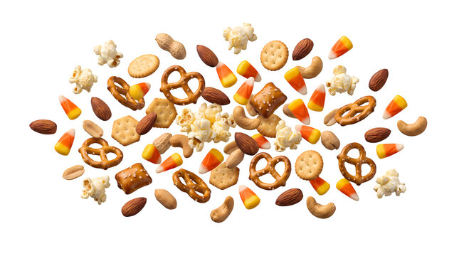 Crunchy snack mix with popcorn pretzels nuts and candy corn scattered isolated.
