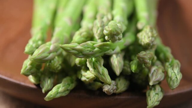 Fresh Green Asparagus Spears on Wooden Plate