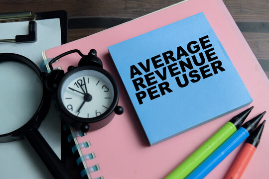 Concept of average revenue per user write on sticky notes isolated on Wooden Table.