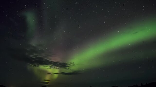 Vibrant Green Aurora Borealis Shimmering Above Reflective Water Surface at Night.