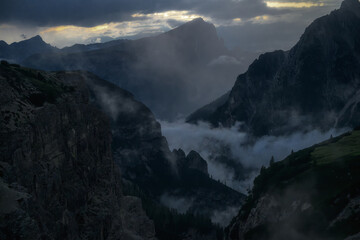 A moody and atmospheric landscape of misty mountain peaks and valleys at dusk. Perfect for travel and nature themes. © marcodenaro