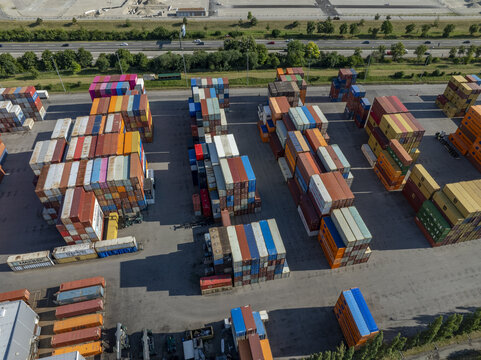 Munich, Bavaria, Germany - 20 July 2026: Aerial view of Container Depot Munchen with rows of colorful shipping containers stacked in a large logistics yard near a highway.