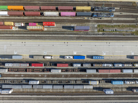 Munich, Germany - 20 July 2026: Aerial view of Container Depot Munchen with colorful shipping containers arranged in rows on freight trains and tracks in an industrial logistics hub.