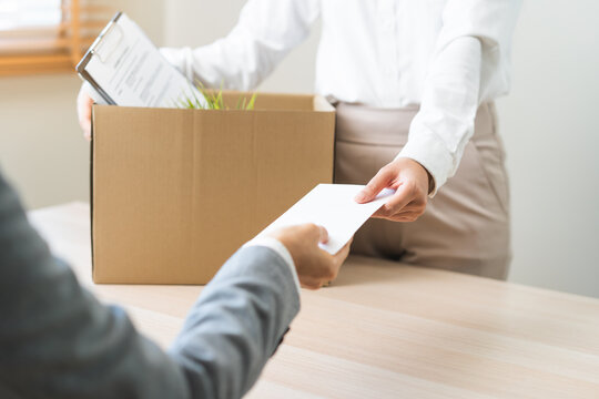 Unemployment quitting job, desperate asian young business woman send resignation letter to boss, resigning from company,holding belongs, pack stuff in box, layoff or leaving, changing work employment