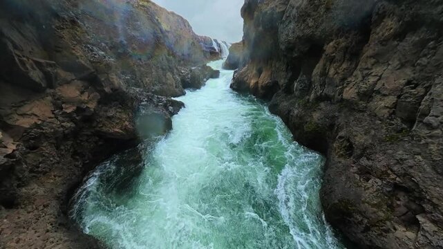 Slow Aerial Drone Ascends Iceland Basalt Canyon Upstream Waterfall Reveal