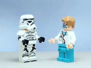 Naklejka premium Indonesia - May 16, 2025 : Mini toy of action figure at table with blurred background. Miniature photography concept design. Minifigure of Stormtrooper and doctor character at hospital clinic.