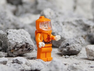 Fototapeta premium Indonesia - May 8, 2025 : Mini toy of action figure at table with blurred background. Miniature photography concept. Hazmat costume conceptual design. Science crew with protection suit.