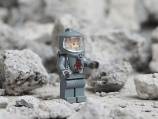 Fototapeta premium Indonesia - May 8, 2025 : Mini toy of action figure at table with blurred background. Miniature photography concept. Hazmat costume conceptual design. Science crew with protection suit.