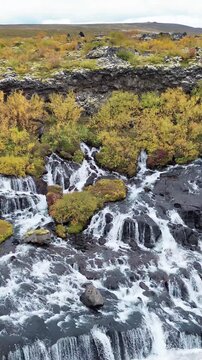 Breathtaking aerial footage captures the dynamic beauty of Barnafoss waterfall cascading over rocks.