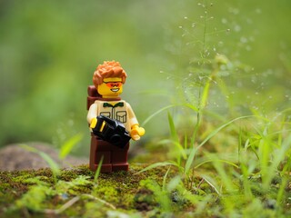 Fototapeta premium Indonesia - February 14, 2023 : Mini toy of action figure at grassland with blurred background. Toy photography concept. Adventure man concept design.