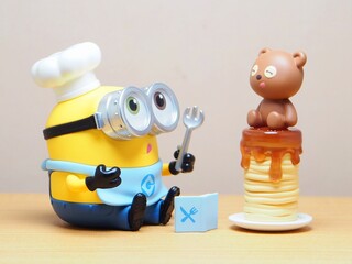Naklejka premium Indonesia - February 22, 2026 : Mini toy of action figure at outdoor with blur background. Miniature photography concept design. Minifigure of Minions character from Despicable Me film as a chef.