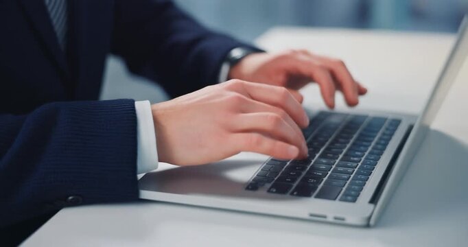 Close-up of business man hands typing on a laptop computer