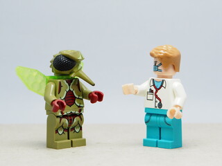 Fototapeta premium Indonesia - December 10, 2025 : Mini toy of action figure at outdoor with blurred background. Miniature photography concept design. Minifigure of doctor and insect mosquito character. Healthcare theme