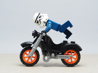 Fototapeta premium Indonesia - December 5, 2025 : Mini toy of action figure at outdoor with blurred background. Miniature photography concept design. Minifigure of freestyler athlete character jumping with motorcycle.