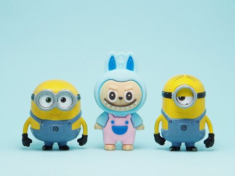Indonesia - November 3, 2025 : Mini toy of action figure at outdoor with blurred background. Miniature photography concept design. Minions character from Despicable Me Cartoon film and Labubu doll.
