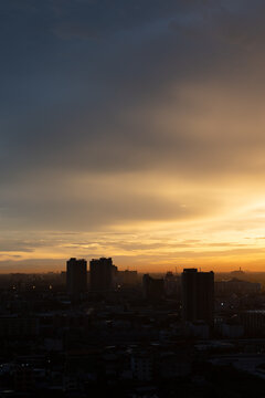 Sunset cityscape skyline silhouette cloud dusk urban tower warm sky over dark building silhouette and hazy metropolitan horizon