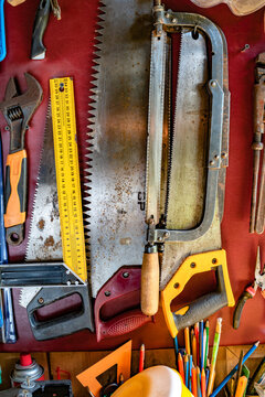 Vintage hand tools arranged on workshop wall background