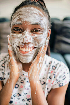 Closeup portrait of happy african american woman doing skincare 