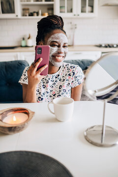 Portrait of a happy african american woman making selfie at home