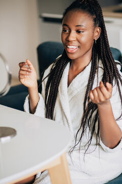 Happy african american woman looking at herself into the mirror 