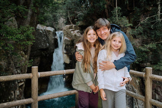 Father with daughters by the waterfall