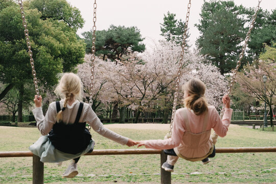 Two girl swinging in the park