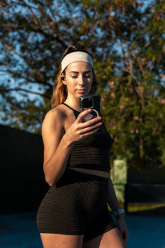 City runner holding a smartphone and browsing a fitness app