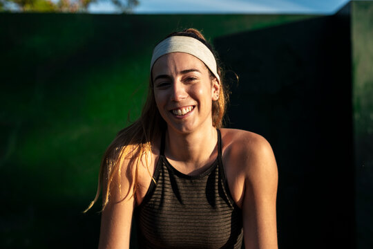 Joyful sporty female laughing after an outdoor workout