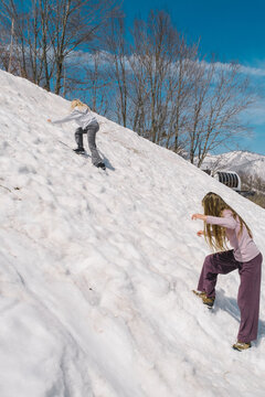 Children are on the snowy hill in the mountains
