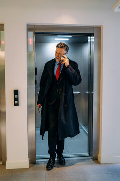 A man talking on a mobile phone in an elevator