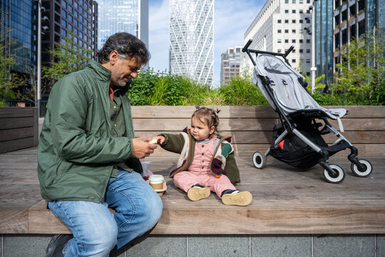 Father Giving A Healthy Snack To Baby Girl During London Visit