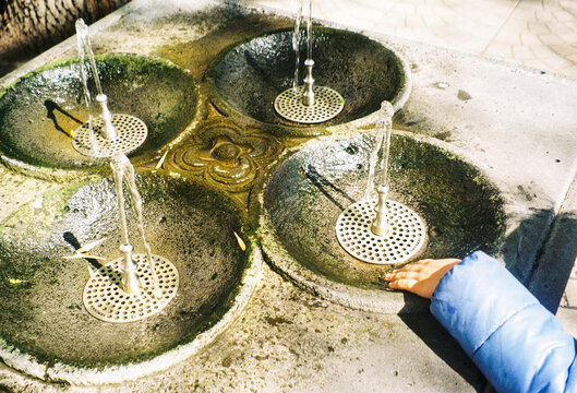 Water Flows From Four Spouts at Outdoor Fountain in City Park