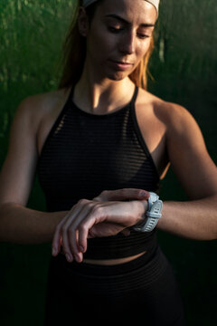 Athletic female reading smartwatch metrics on her wrist