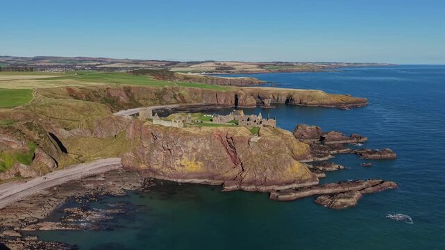 Beautiful cinematic Aerial footage of Dunnottar Castle and Dramatic Cliffs, Stonehaven Scotland &ndash; Historic Medieval Fortress on the North Sea	
