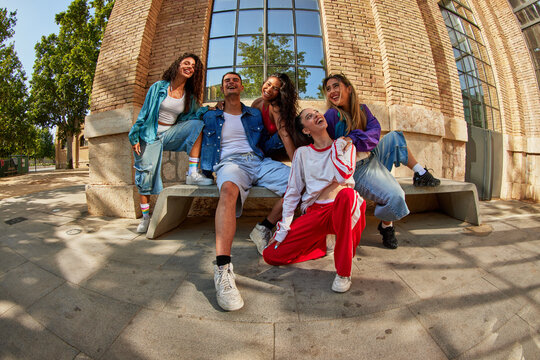 Friends gather on a sunny day in a city park for fun and laughte