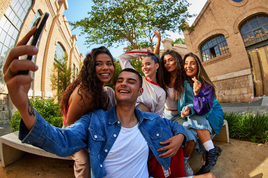 Group of friends taking selfie in urban park during sunny day
