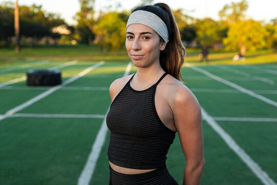 Resolute woman standing on outdoor training field