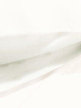 Soft white fabric folds creating an abstract minimalist background with subtle shadows and gentle curves, suitable for elegant product photography, branding, packaging, and graphic design.