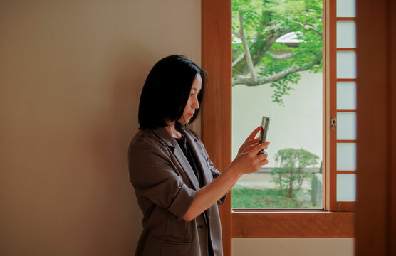 A professional woman on a video call by a window.