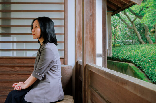 A Woman Sitting in Quiet Contemplation on a Japanese Veranda.