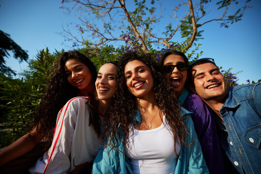 Group of friends smiling together in a garden on a sunny day