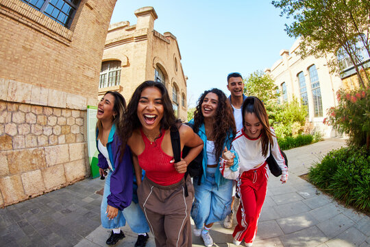 Group of friends enjoy a sunny day in the city while walking tog