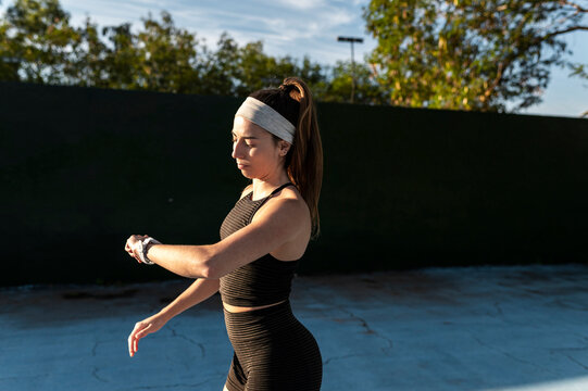 Fit woman checking a fitness smartwatch outdoors