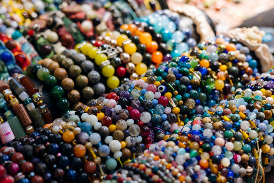 Colorful handmade gemstone bead bracelets displayed at an artisan market stall.