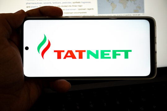 Hand holding device displaying tatneft oil company logo