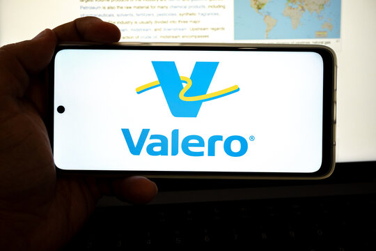 Hand holding device displaying valero energy company logo
