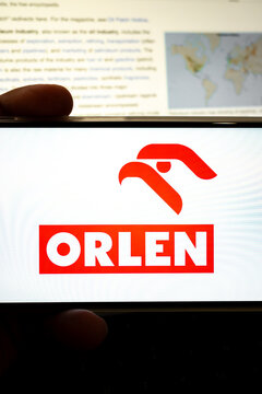 Person holding device showing orlen company logo