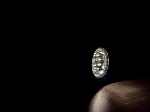 Flashlight beam shining in a dark room, creating a focused light spot and strong contrast, highlighting visibility, direction, and minimal illumination in a low-light environment.