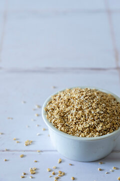 Steel cut oats in a white ceramic bowl on a tile surface 
