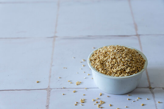 Steel cut oats in a white ceramic bowl on a tile surface 